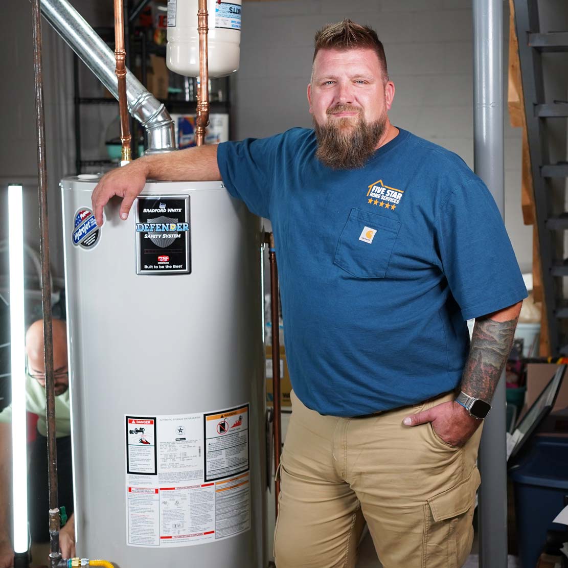 Plumber Standing next to a Tank Heater