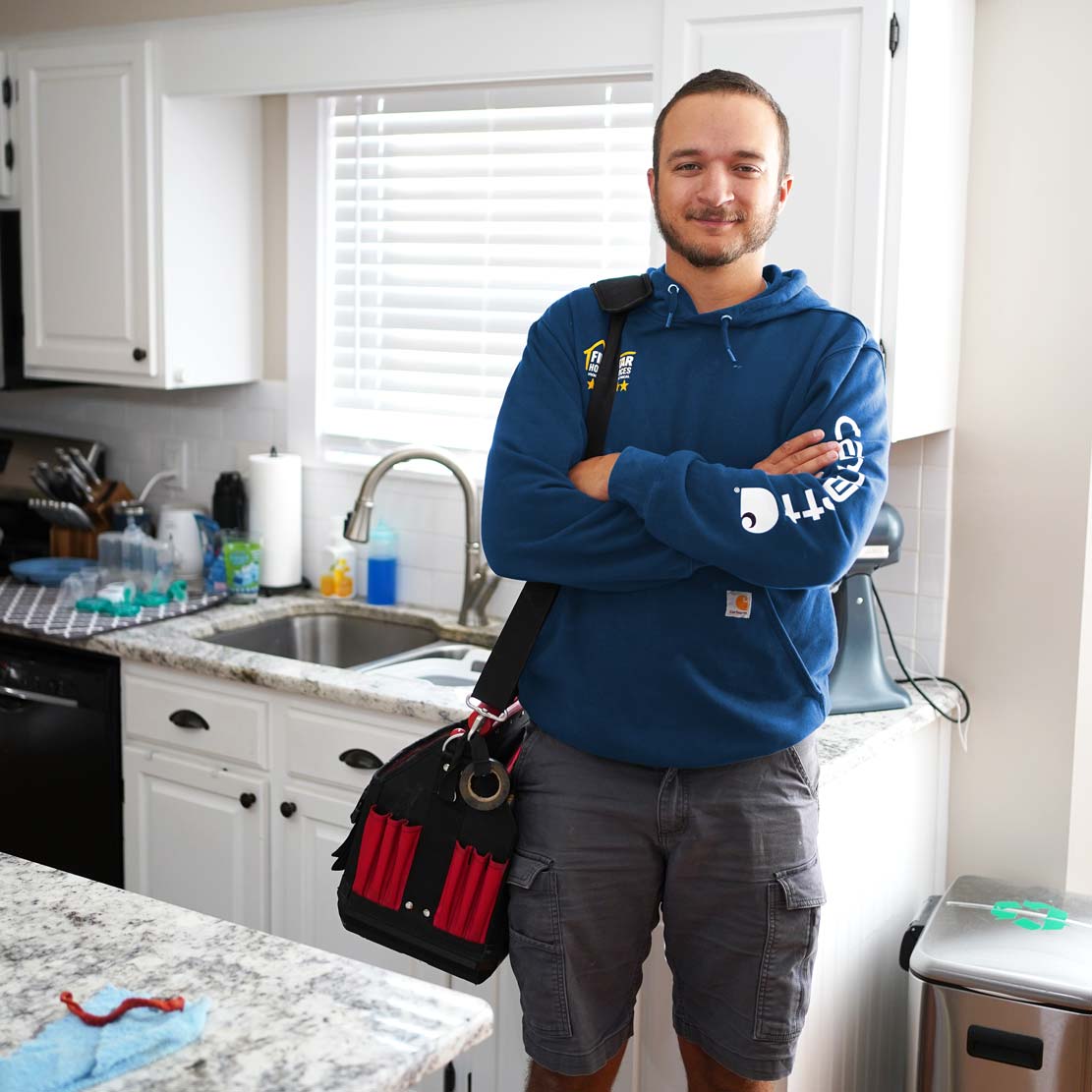 Plumber standing next to a kitchen sink